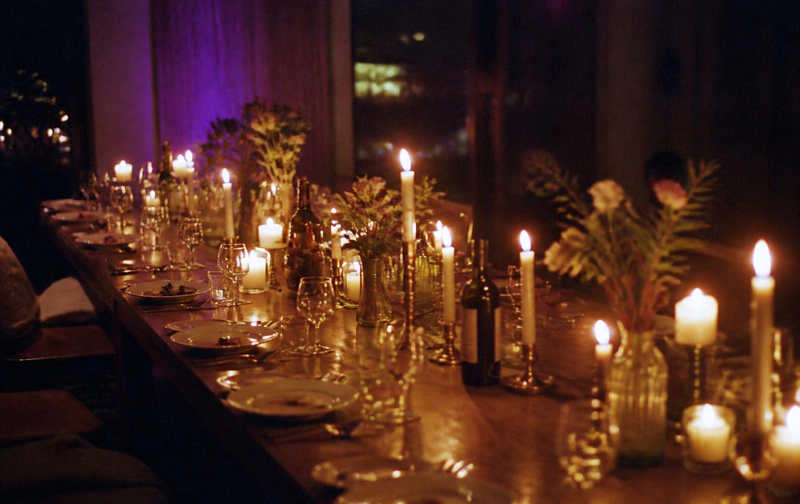 Many candles glowing together in a dark room